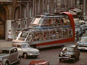 Movie still from “Zazie dans le Métro” (1960), directed by Louis Malle – An old photo of a bus driving down the street; Extreme Wide shot, High angle