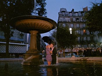 Movie still from “Zazie dans le Métro” (1960), directed by Louis Malle – A man and a woman kissing in a fountain at night; Wide shot, High angle