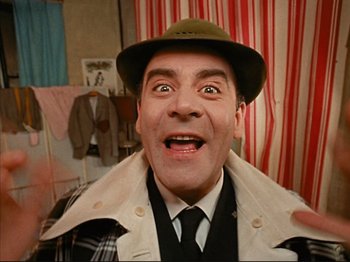 Movie still from “Zazie dans le Métro” (1960), directed by Louis Malle – A person wearing a hat and a coat; Close Up shot, Overhead angle