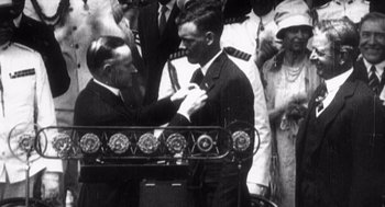 Movie still from “Zelig” (1983), directed by Woody Allen – A man in a suit and tie is pinning a tie on another man's neck; Close Up shot, Low angle