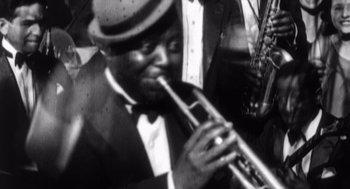 Movie still from “Zelig” (1983), directed by Woody Allen – A black and white photo of a man playing a trumpet; Extreme Close Up shot, High angle