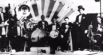 Movie still from “Zelig” (1983), directed by Woody Allen – A black and white photo of a group of men playing musical instruments; Extreme Wide shot, Low angle