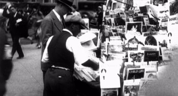 Movie still from “Zelig” (1983), directed by Woody Allen – Two men in hats and vests are looking at newspapers; Medium shot, High angle