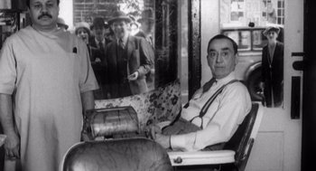 Movie still from “Zelig” (1983), directed by Woody Allen – An old photo of a man sitting in a chair; Medium shot, Low angle