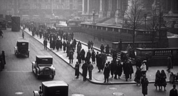 Movie still from “Zelig” (1983), directed by Woody Allen – A black and white photo of people walking down a street; Extreme Wide shot, High angle
