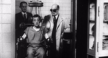 Movie still from “Zelig” (1983), directed by Woody Allen – An old photo of a man sitting in a dentist chair; Medium shot, Low angle