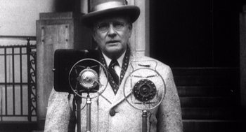 Movie still from “Zelig” (1983), directed by Woody Allen – An older man wearing a hat and glasses; Close Up shot, Low angle