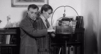 Movie still from “Zelig” (1983), directed by Woody Allen – A man and a woman standing next to each other in a room; Medium shot, Low angle