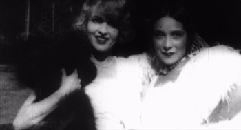 Movie still from “Zelig” (1983), directed by Woody Allen – Two young women pose for a picture in a black and white photo; Close Up shot, Low angle