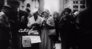 Movie still from “Zelig” (1983), directed by Woody Allen – A group of people standing around a table; Medium shot, High angle