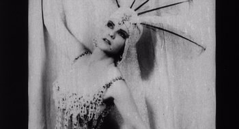 Movie still from “Zelig” (1983), directed by Woody Allen – A black and white photo of a woman in a costume; Medium shot, Low angle