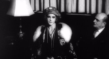 Movie still from “Zelig” (1983), directed by Woody Allen – An old photo of a woman wearing a hat and fur coat; Medium shot, Low angle