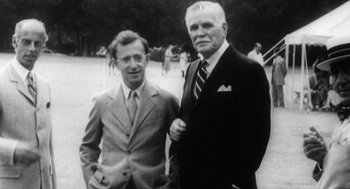 Movie still from “Zelig” (1983), directed by Woody Allen – Two men standing next to each other on a field; Medium shot, Low angle