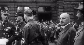 Movie still from “Zelig” (1983), directed by Woody Allen – A black and white photo of a group of men in uniform; Medium shot, Over the shoulder angle
