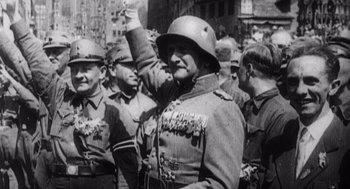 Movie still from “Zelig” (1983), directed by Woody Allen – An old photo of a man in a uniform saluting in front of a group of men; Medium shot, High angle
