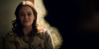 Movie still from “Archive 81” (2022), created by Rebecca Sonnenshine – A young woman is smiling for the camera; Close Up shot, Over the shoulder angle