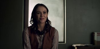 Movie still from “Archive 81” (2022), created by Rebecca Sonnenshine – A woman in a striped shirt is smiling; Close Up shot, Over the shoulder angle