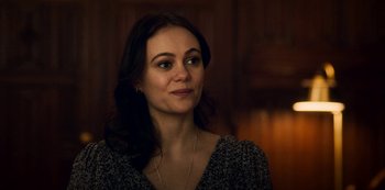 Movie still from “Archive 81” (2022), created by Rebecca Sonnenshine – A beautiful woman with long dark hair wearing a necklace; Close Up shot, Over the shoulder angle