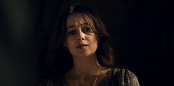 Movie still from “Archive 81” (2022), created by Rebecca Sonnenshine – A person wearing a necklace; Close Up shot, Low angle