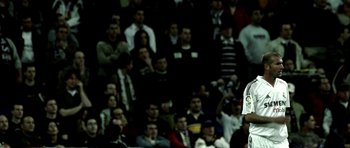 Movie still from “Zidane: A 21st Century Portrait” (2006), directed by Philippe Parreno – A crowd of people watching a baseball game in a stadium; Medium shot, Low angle
