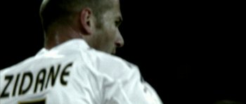 Movie still from “Zidane: A 21st Century Portrait” (2006), directed by Philippe Parreno – A person wearing a white shirt; Extreme Close Up shot, Over the shoulder angle