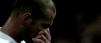 Movie still from “Zidane: A 21st Century Portrait” (2006), directed by Philippe Parreno – A person holding his hands to his face; Extreme Close Up shot, Low angle