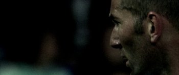 Movie still from “Zidane: A 21st Century Portrait” (2006), directed by Philippe Parreno – A person's face in the dark; Extreme Close Up shot, Over the shoulder angle