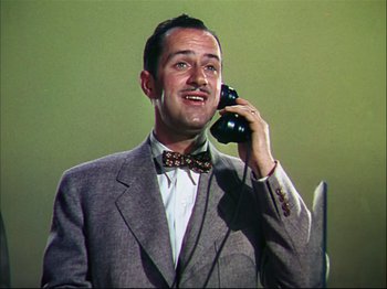 Movie still from “Ziegfeld Follies” (1945), directed by Roy Del Ruth – A man talking on a phone while wearing a suit and bow tie; Close Up shot, Low angle
