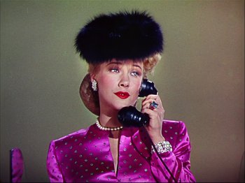 Movie still from “Ziegfeld Follies” (1945), directed by Roy Del Ruth – A woman wearing a fur hat talking on a phone; Close Up shot, Low angle