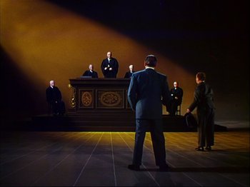Movie still from “Ziegfeld Follies” (1945), directed by Roy Del Ruth – A group of people standing in front of a judge; Extreme Wide shot, High angle