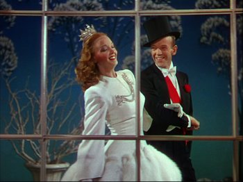 Movie still from “Ziegfeld Follies” (1945), directed by Roy Del Ruth – A man and a woman dressed up as a snow queen and a man in a top hat; Medium shot, Low angle