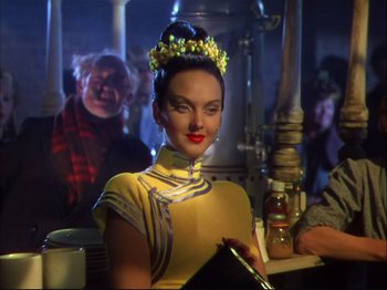 Movie still from “Ziegfeld Follies” (1945), directed by Roy Del Ruth – A woman in a yellow dress and a flower crown; Medium shot, Over the shoulder angle