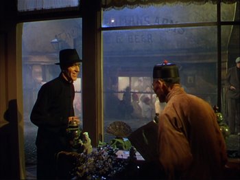 Movie still from “Ziegfeld Follies” (1945), directed by Roy Del Ruth – Two men wearing hats and standing in front of a table; Medium shot, Over the shoulder angle