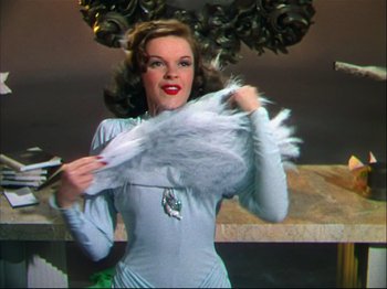 Movie still from “Ziegfeld Follies” (1945), directed by Roy Del Ruth – A woman holding a feather duster in her hand; Medium shot, Low angle