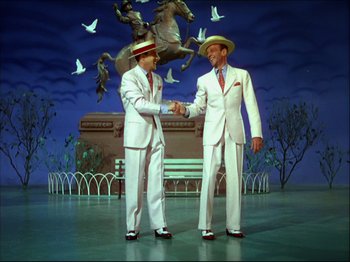 Movie still from “Ziegfeld Follies” (1945), directed by Roy Del Ruth – A couple of men shaking hands on a stage; Wide shot, High angle