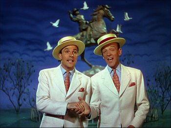 Movie still from “Ziegfeld Follies” (1945), directed by Roy Del Ruth – A couple of men standing next to each other in suits; Medium shot, Low angle