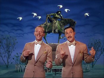 Movie still from “Ziegfeld Follies” (1945), directed by Roy Del Ruth – A couple of men standing next to each other in suits; Medium shot, Low angle