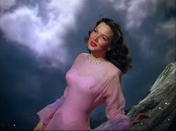 Movie still from “Ziegfeld Follies” (1945), directed by Roy Del Ruth – A woman in a pink dress posing for a picture; Medium shot, Low angle