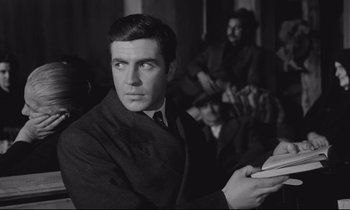 Movie still from “Zorba the Greek” (1964), directed by Michael Cacoyannis – Black and white photograph of a man wearing a suit and tie; Medium shot, Low angle