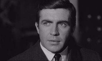 Movie still from “Zorba the Greek” (1964), directed by Michael Cacoyannis – Black and white photograph of a man in a suit and tie; Close Up shot, Low angle