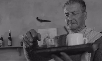 Movie still from “Zorba the Greek” (1964), directed by Michael Cacoyannis – An older man holding a tray of food; Close Up shot, Low angle
