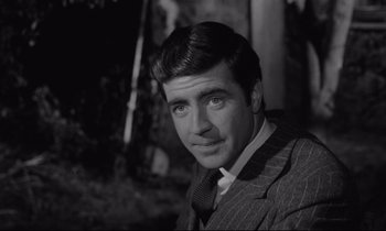 Movie still from “Zorba the Greek” (1964), directed by Michael Cacoyannis – Black and white photograph of a man wearing a suit; Close Up shot, Low angle