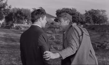 Movie still from “Zorba the Greek” (1964), directed by Michael Cacoyannis – Two men talking to each other in an open field; Medium shot, Over the shoulder angle