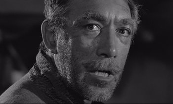 Movie still from “Zorba the Greek” (1964), directed by Michael Cacoyannis – Black and white photograph of a man's face; Close Up shot, Low angle