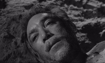Movie still from “Zorba the Greek” (1964), directed by Michael Cacoyannis – Black and white photograph of a bearded man's face; Close Up shot, High angle