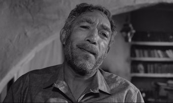 Movie still from “Zorba the Greek” (1964), directed by Michael Cacoyannis – An older man with a beard and mustache; Close Up shot, Low angle