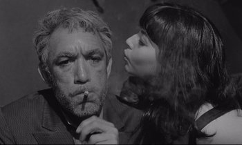 Movie still from “Zorba the Greek” (1964), directed by Michael Cacoyannis – A man and a woman are smoking a cigarette together; Close Up shot, Low angle