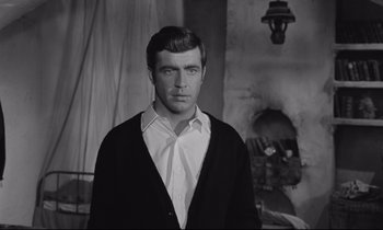 Movie still from “Zorba the Greek” (1964), directed by Michael Cacoyannis – Black and white photograph of a man wearing a white shirt; Medium shot, Low angle