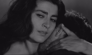 Movie still from “Zorba the Greek” (1964), directed by Michael Cacoyannis – A black - and - white photo of a woman holding a man's arm; Close Up shot, High angle