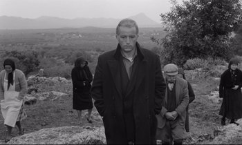 Movie still from “Zorba the Greek” (1964), directed by Michael Cacoyannis – Black and white photograph of a man and two women; Wide shot, Low angle